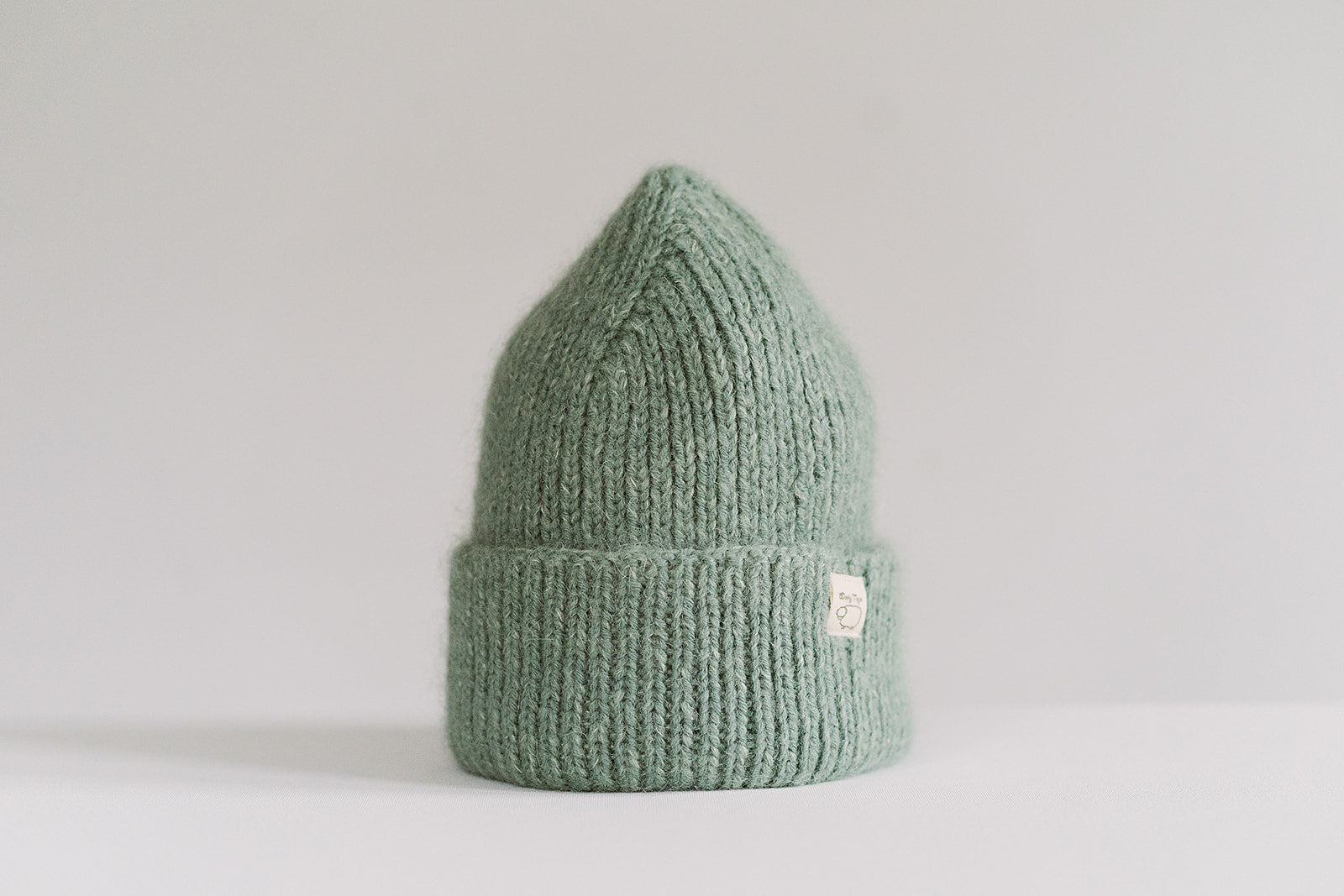 Hand-knitted Wooly Top hat in green.